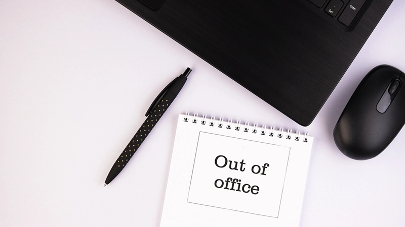 out of office note in front of laptop