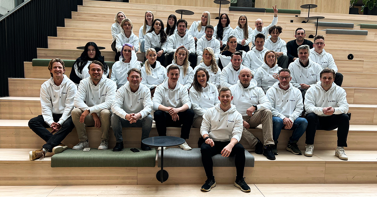 Team Members of WP SEO AI sitting on wooden stairs for a groups picture