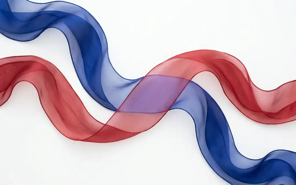 Cobalt blue and crimson silk ribbons flowing in parallel curves, overlapping at center to form soft violet, on white background.